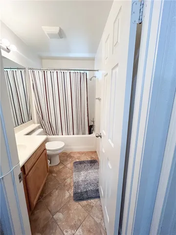 a living room with furniture a flat screen tv and gym equipment