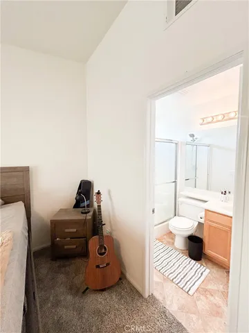 a spacious bedroom with a bed a couch and a chandelier