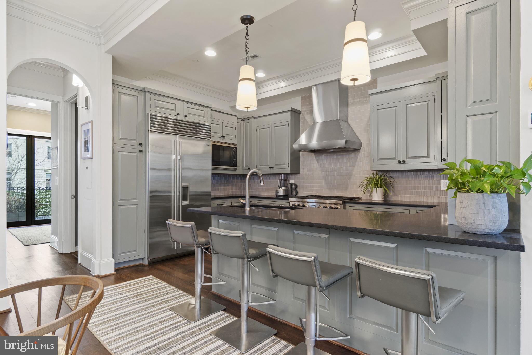 1335 R Street Northwest, Unit 2 Washington, DC 20009 - Photo 6 of 27 a kitchen with stainless steel appliances granite countertop a refrigerator a sink dishwasher a dining table and chairs with wooden floor