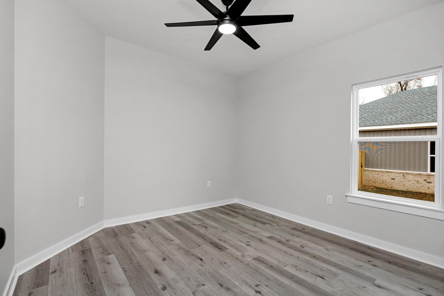 3154 Auburn Road Crestview, FL 32539 - Photo 17 of 25 a view of empty room with wooden floor and window