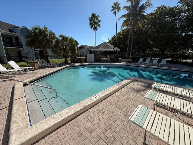 a view of a swimming pool with a patio and a yard