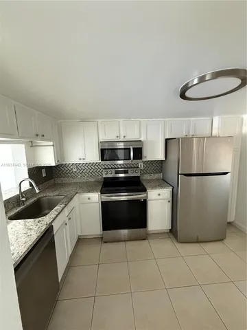 a kitchen with a stove a refrigerator and a sink