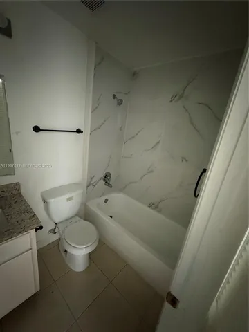 a bathroom with a granite countertop toilet and a sink