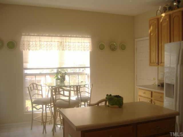 201 Caley Road Apex, NC 27502 - Photo 8 of 12 Kitchen is bright and spacious with island. The Breakfast Room complete with door opening to private rear deck gives easy grilling access. Other