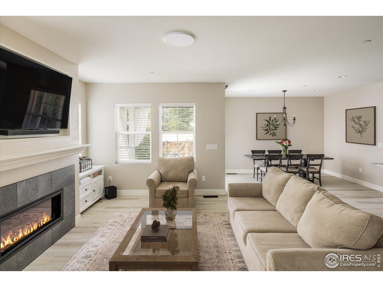 10121 Flower Street Westminster, CO 80021 - Photo 11 of 40 the living room features elegant luxury vinyl plank flooring, seamlessly flowing into the adjacent dining area