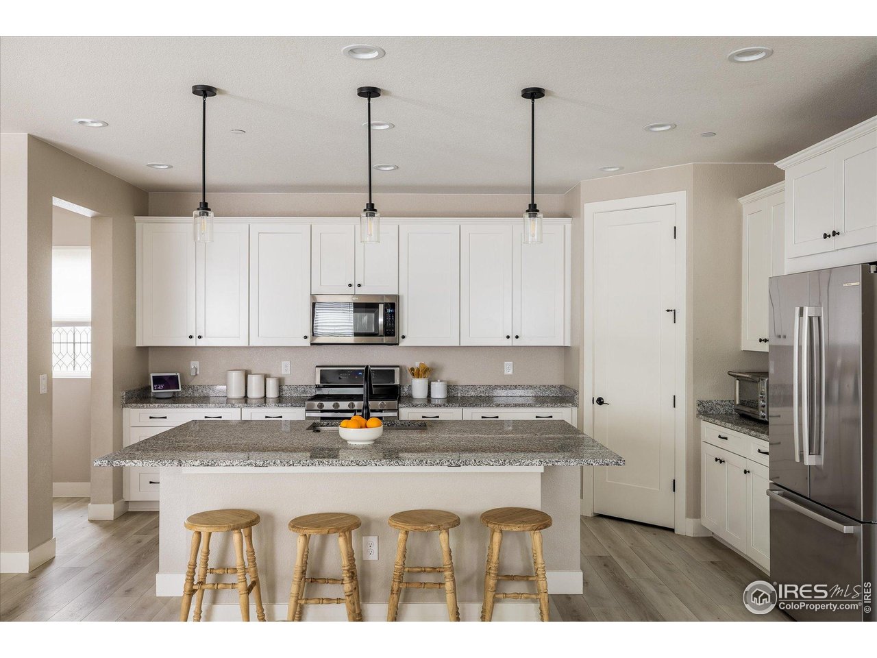 10121 Flower Street Westminster, CO 80021 - Photo 13 of 40 a spacious kitchen with a center island and ample cabinetry
