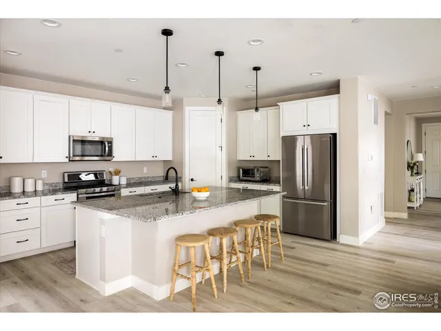 a kitchen with stainless steel appliances a refrigerator sink and white cabinets