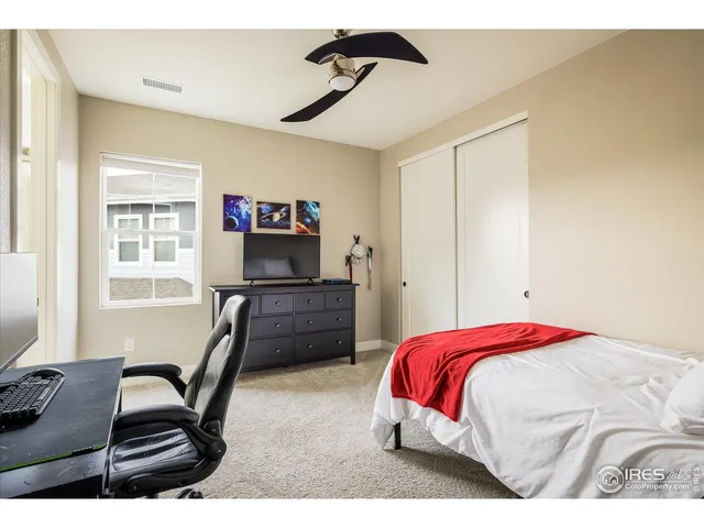 a bedroom with a bed window and a desk
