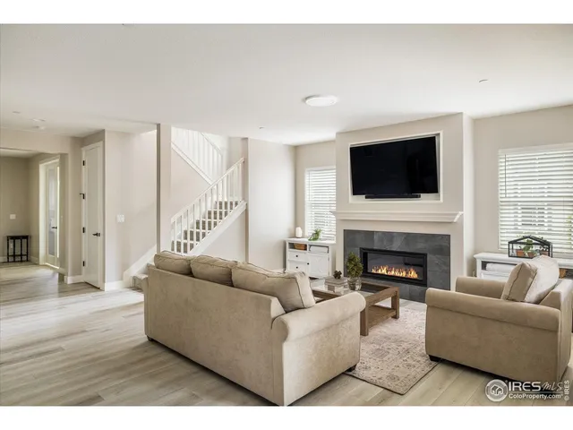 a living room with furniture a flat screen tv and a fireplace