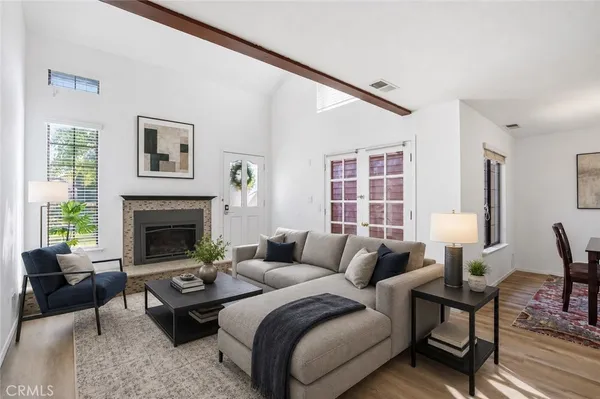 an empty room with windows fireplace and wooden floor