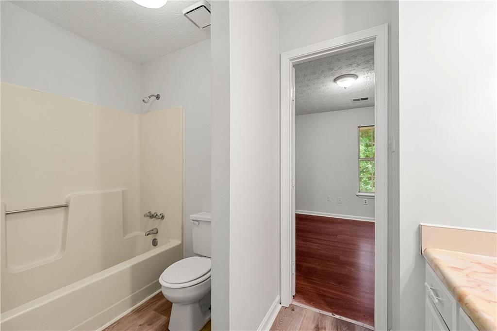 2575 Picardy Circle North, Unit B Atlanta, GA 30349 - Photo 18 of 20 a bathroom with a granite countertop toilet and a sink