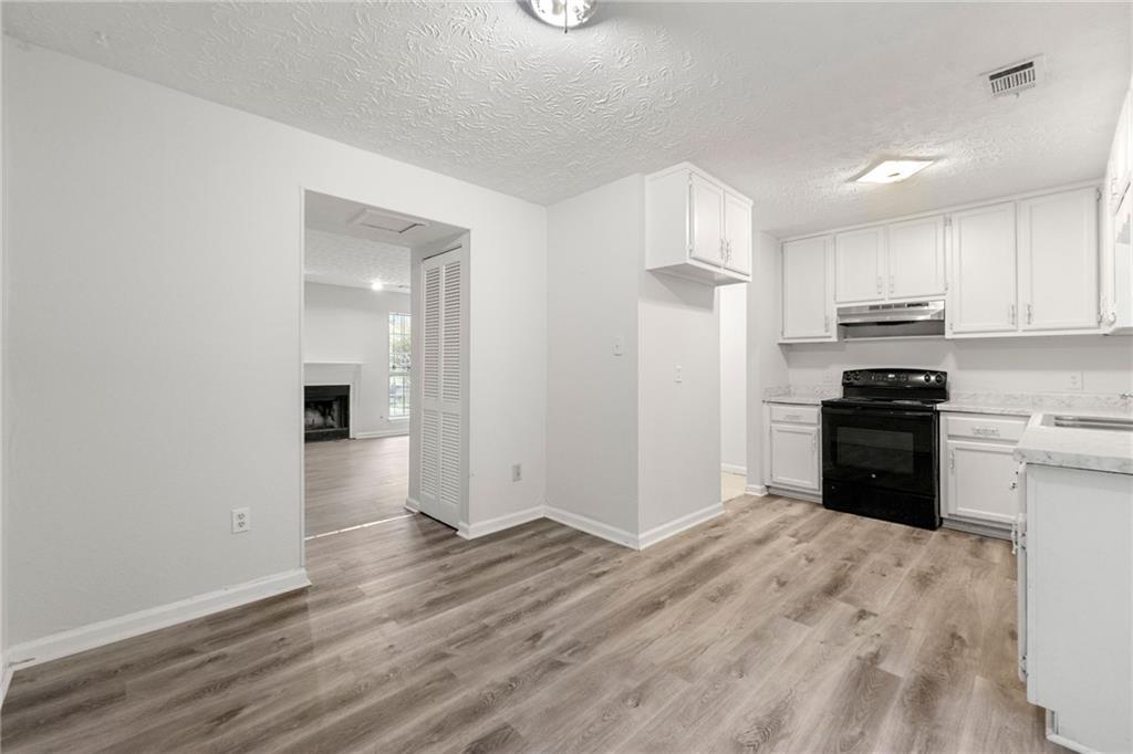2575 Picardy Circle North, Unit B Atlanta, GA 30349 - Photo 6 of 20 a kitchen with granite countertop a refrigerator and a stove top oven