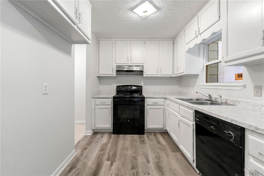 2575 Picardy Circle North, Unit B Atlanta, GA 30349 - Photo 7 of 20 a kitchen with a sink stove top oven and cabinets