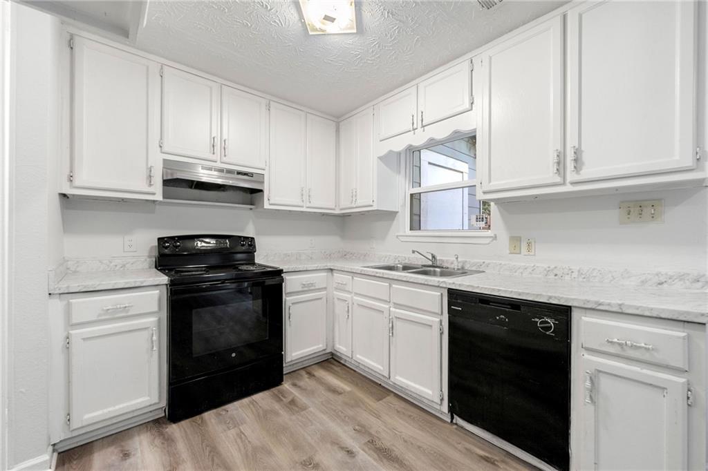 2575 Picardy Circle North, Unit B Atlanta, GA 30349 - Photo 8 of 20 a kitchen with stainless steel appliances granite countertop white cabinets sink and dishwasher