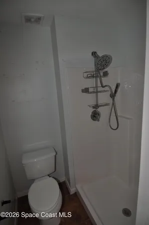 a white toilet sitting next to a bath tub