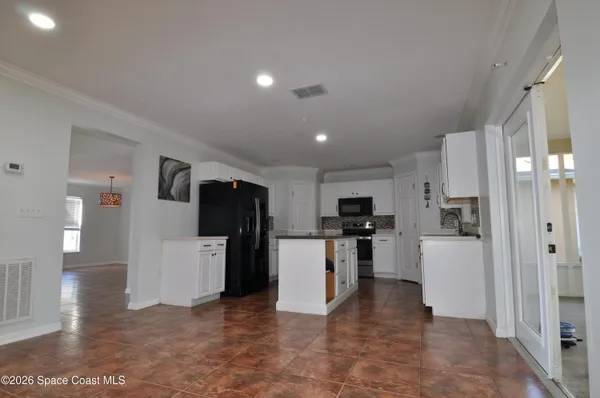 a view of a kitchen with refrigerator and a stove top oven