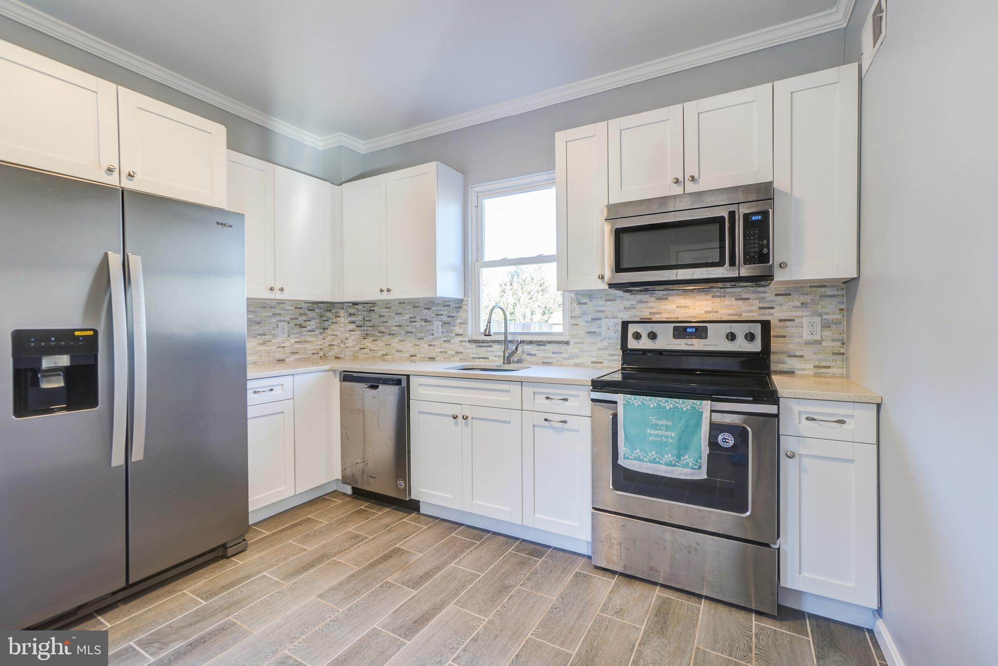 35 4th Street Laurel, MD 20707 - Photo 12 of 31 a kitchen with a refrigerator stove and microwave