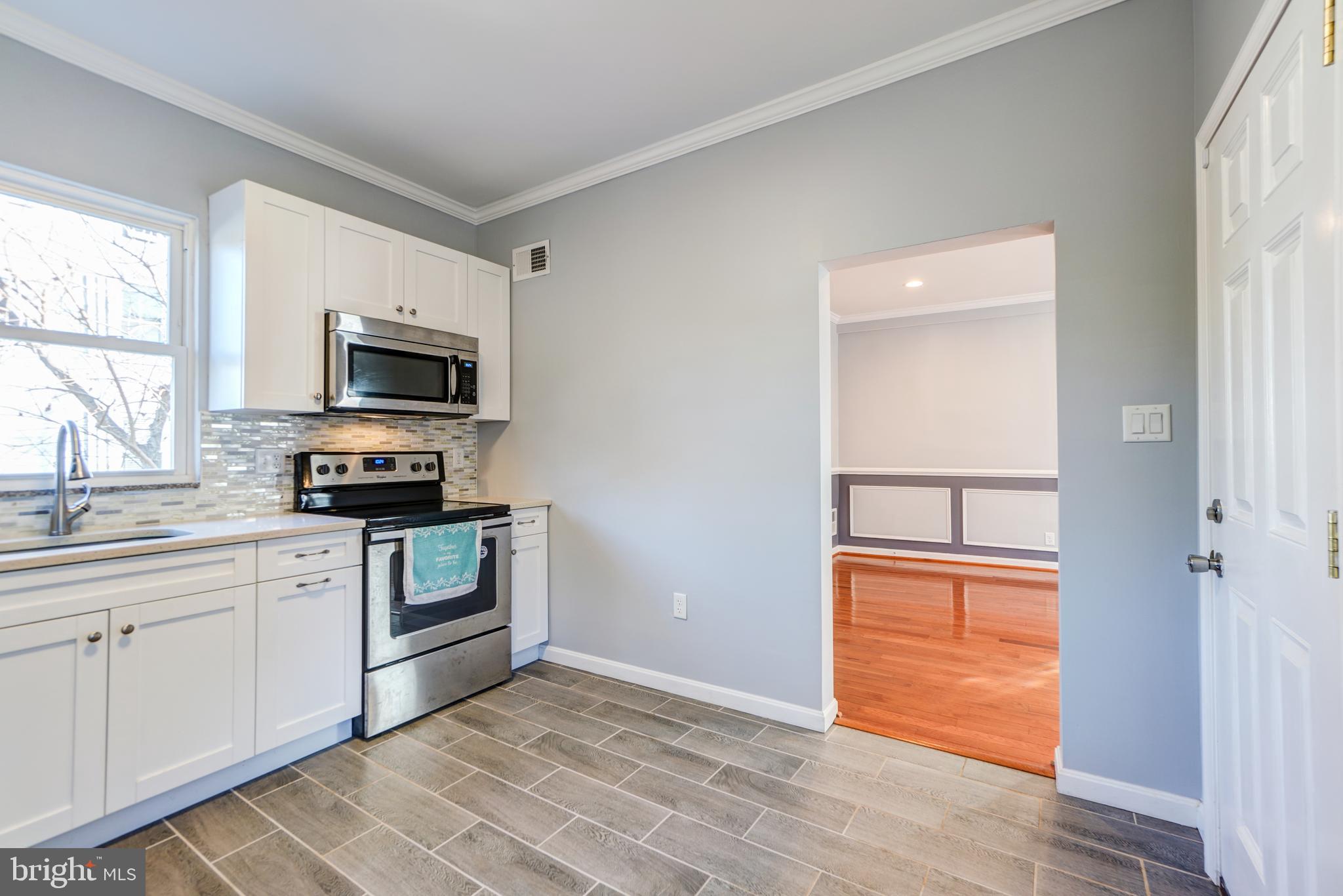 35 4th Street Laurel, MD 20707 - Photo 14 of 31 a kitchen with a stove a sink and a microwave