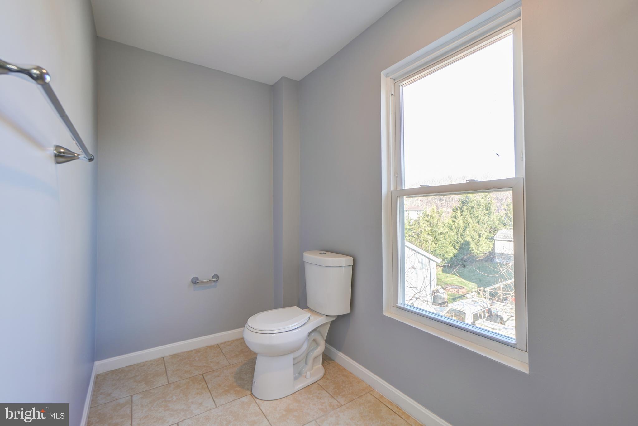 35 4th Street Laurel, MD 20707 - Photo 26 of 31 a white toilet sitting next to a window in a room