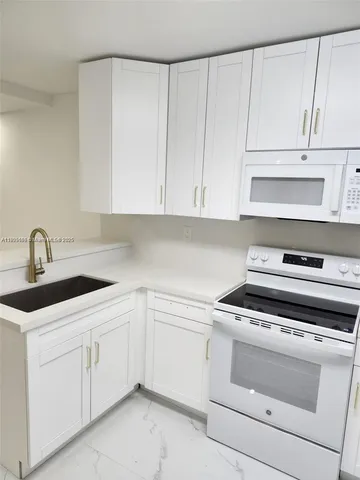 a kitchen with white cabinets and white appliances