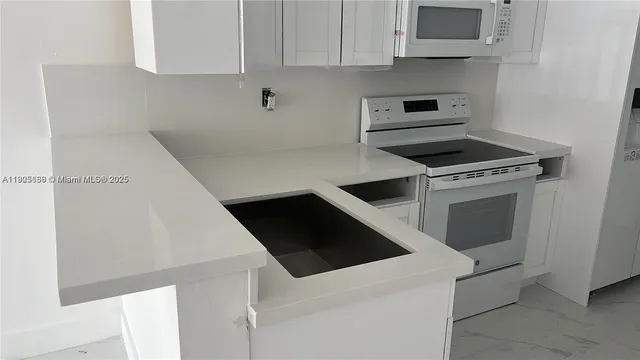 a view of kitchen with sink and refrigerator