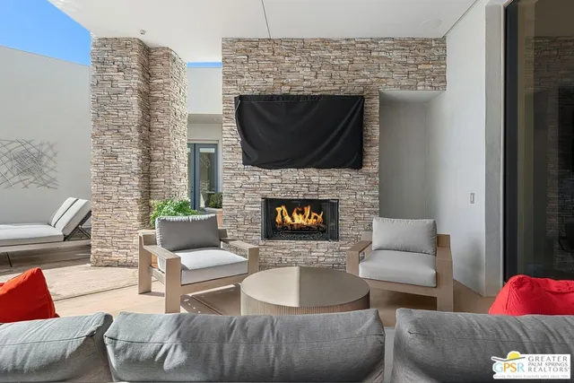 a living room with furniture a fireplace and a chandelier