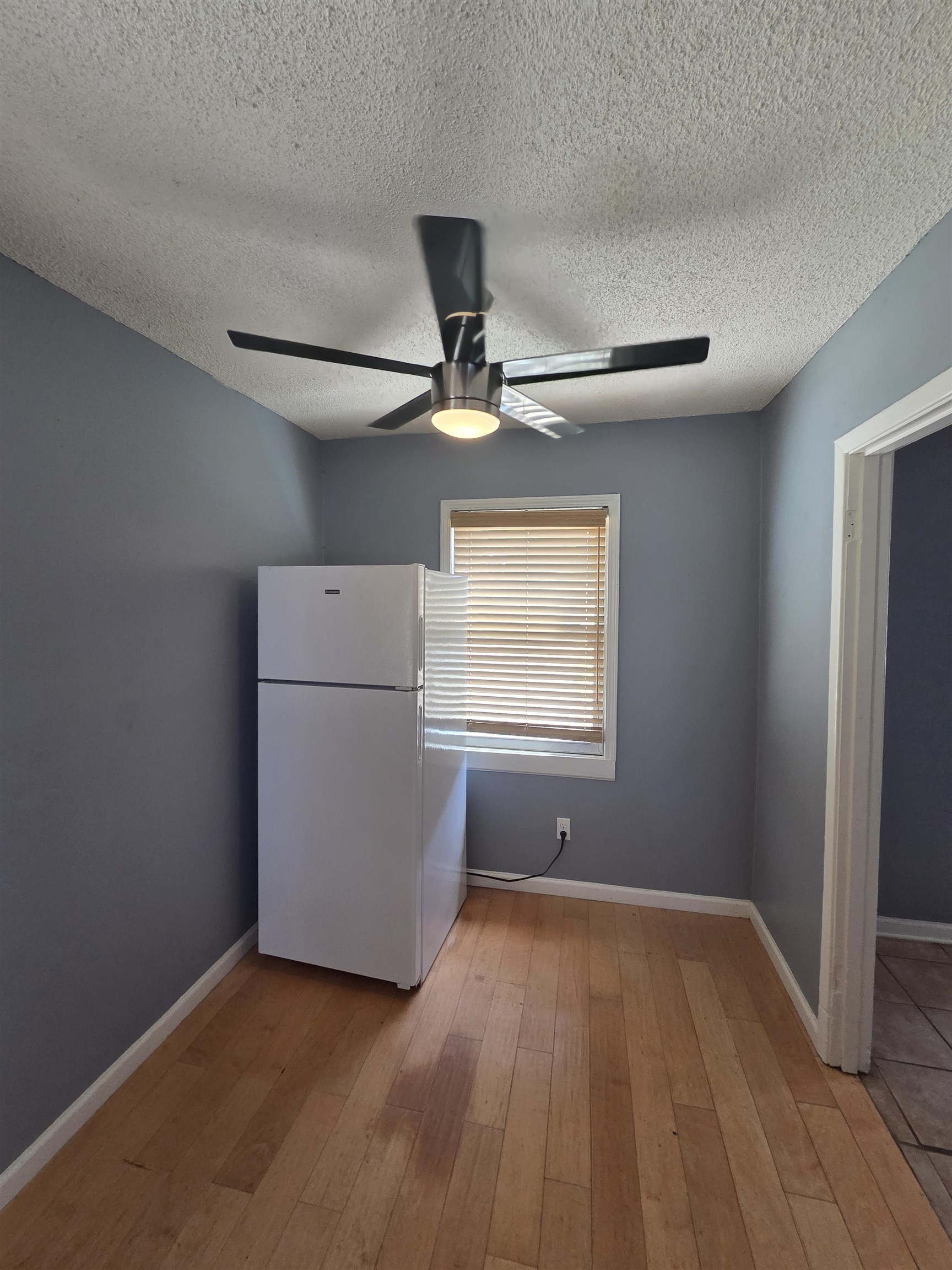 3166 Winslow Road Memphis, TN 38109 - Photo 12 of 17 Kitchen with freestanding refrigerator, a textured ceiling, light wood-style floors, and a ceiling fan
