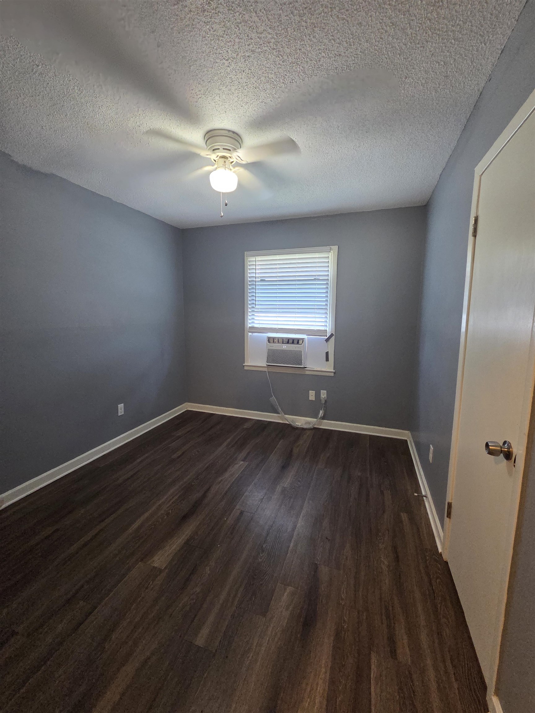 3166 Winslow Road Memphis, TN 38109 - Photo 6 of 17 Unfurnished room with dark wood finished floors, a textured ceiling, and a ceiling fan