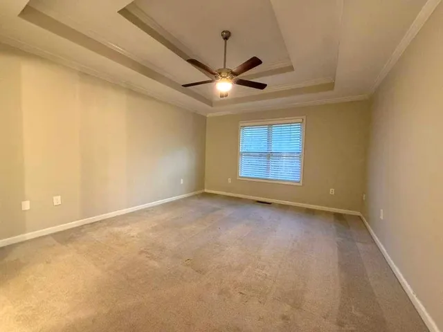 an empty room with a ceiling fan and a window
