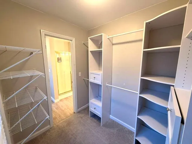 a view of walk in closet with empty racks