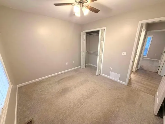an empty room with fan and entrance