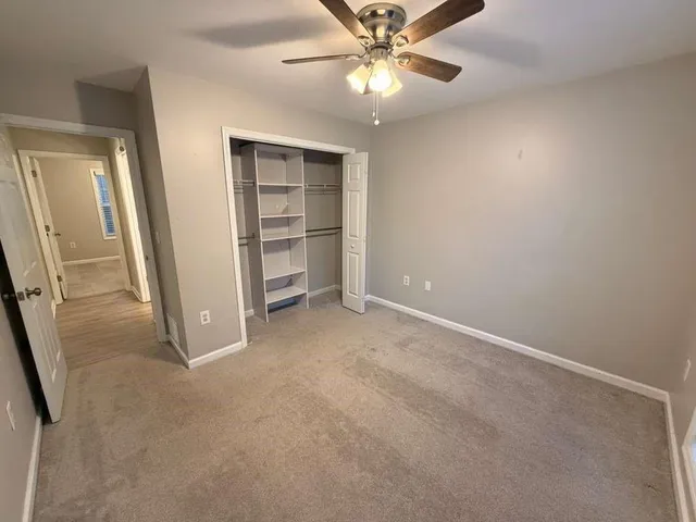 an empty room with closet and windows