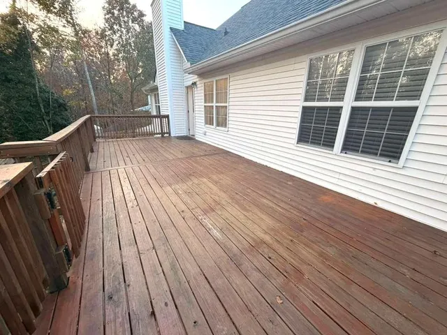 a view of backyard with wooden floor and fence