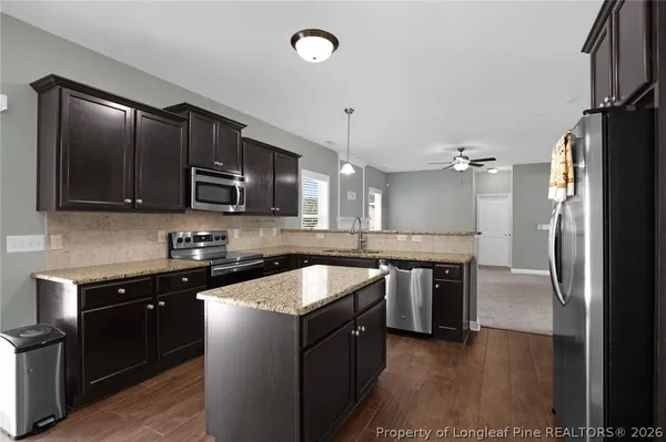 a kitchen with granite countertop cabinets stainless steel appliances and a counter space