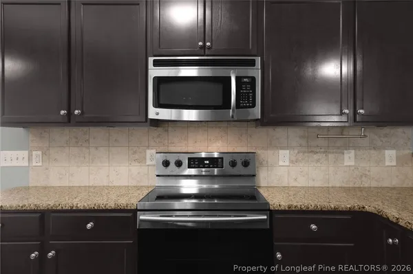 a kitchen with granite countertop stainless steel appliances a refrigerator and a counter space