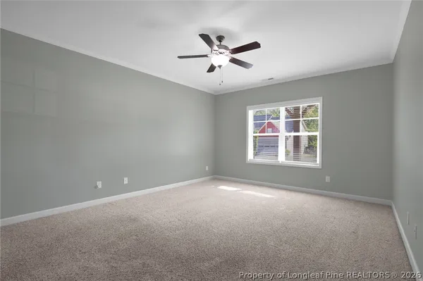 a view of an empty room with a ceiling fan