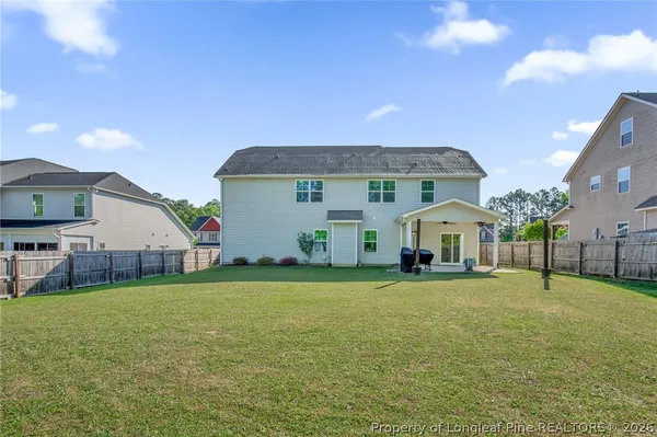 a front view of house with yard and trees in the background