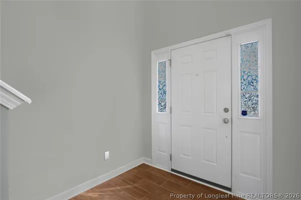 a view of an empty room with a window and chandelier