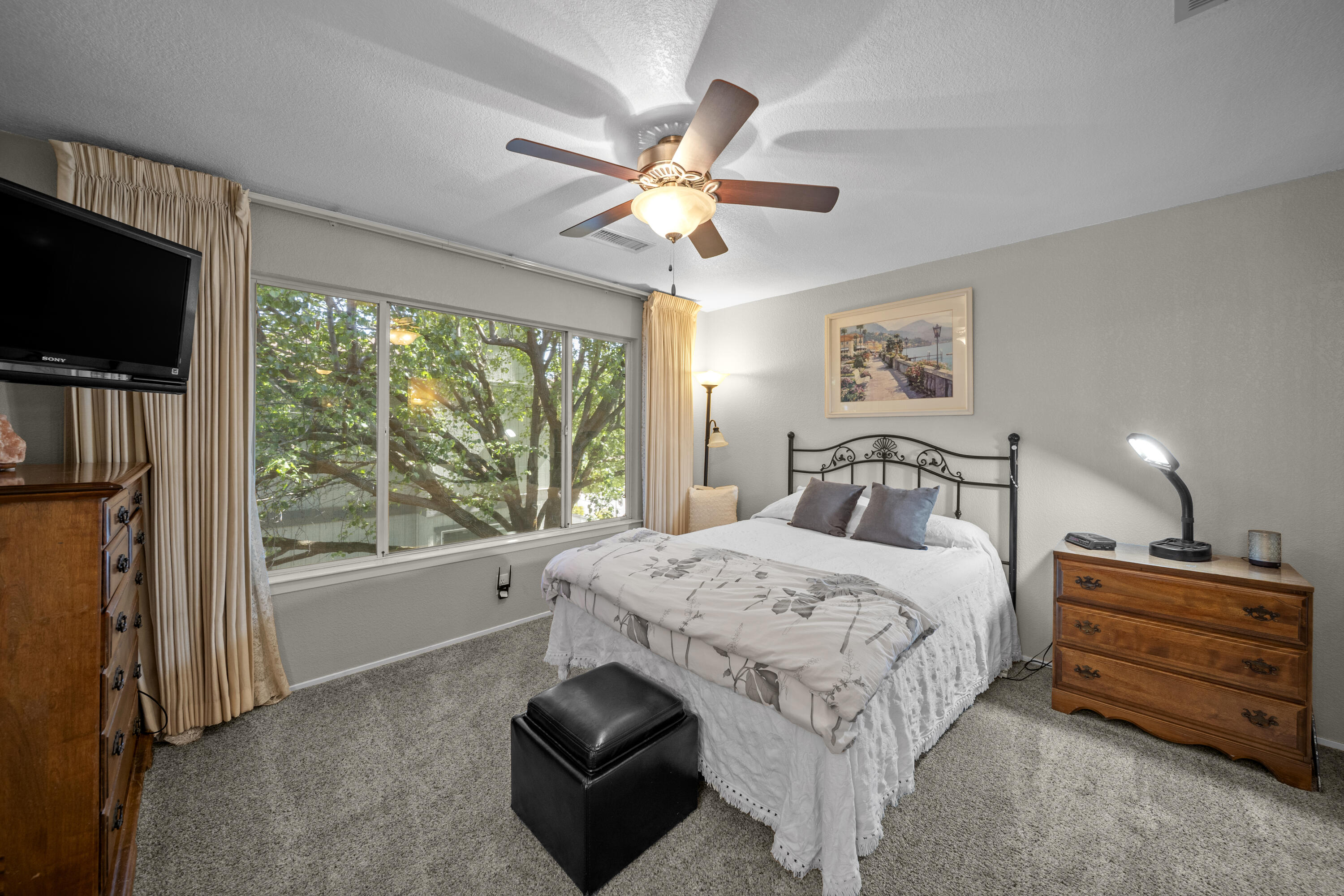 200 Ridgetop Drive, Unit 26 Redding, CA 96003 - Photo 14 of 27 a bedroom with a bed and a flat tv screen on dresser