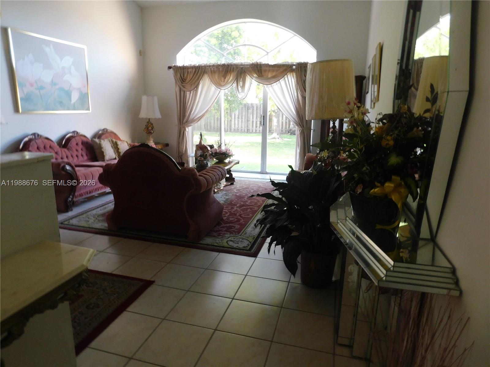 15871 Southwest 82nd Street Miami, FL 33193 - Photo 5 of 7 a living room with furniture and a chandelier