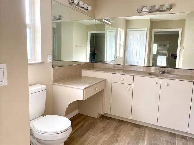 a bathroom with a granite countertop toilet sink and mirror
