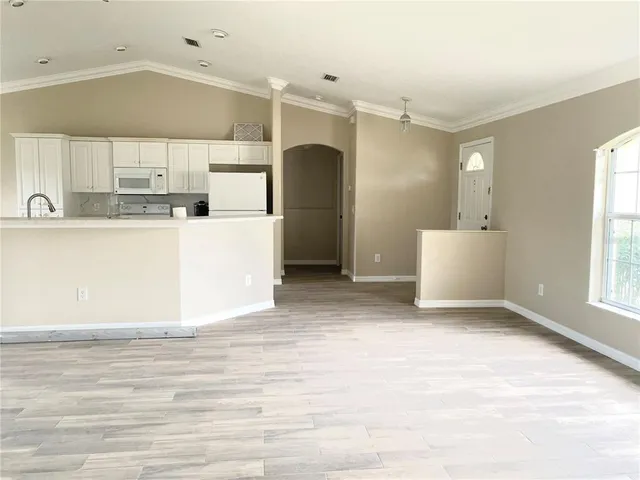 a view of a kitchen with wooden cabinet and a window
