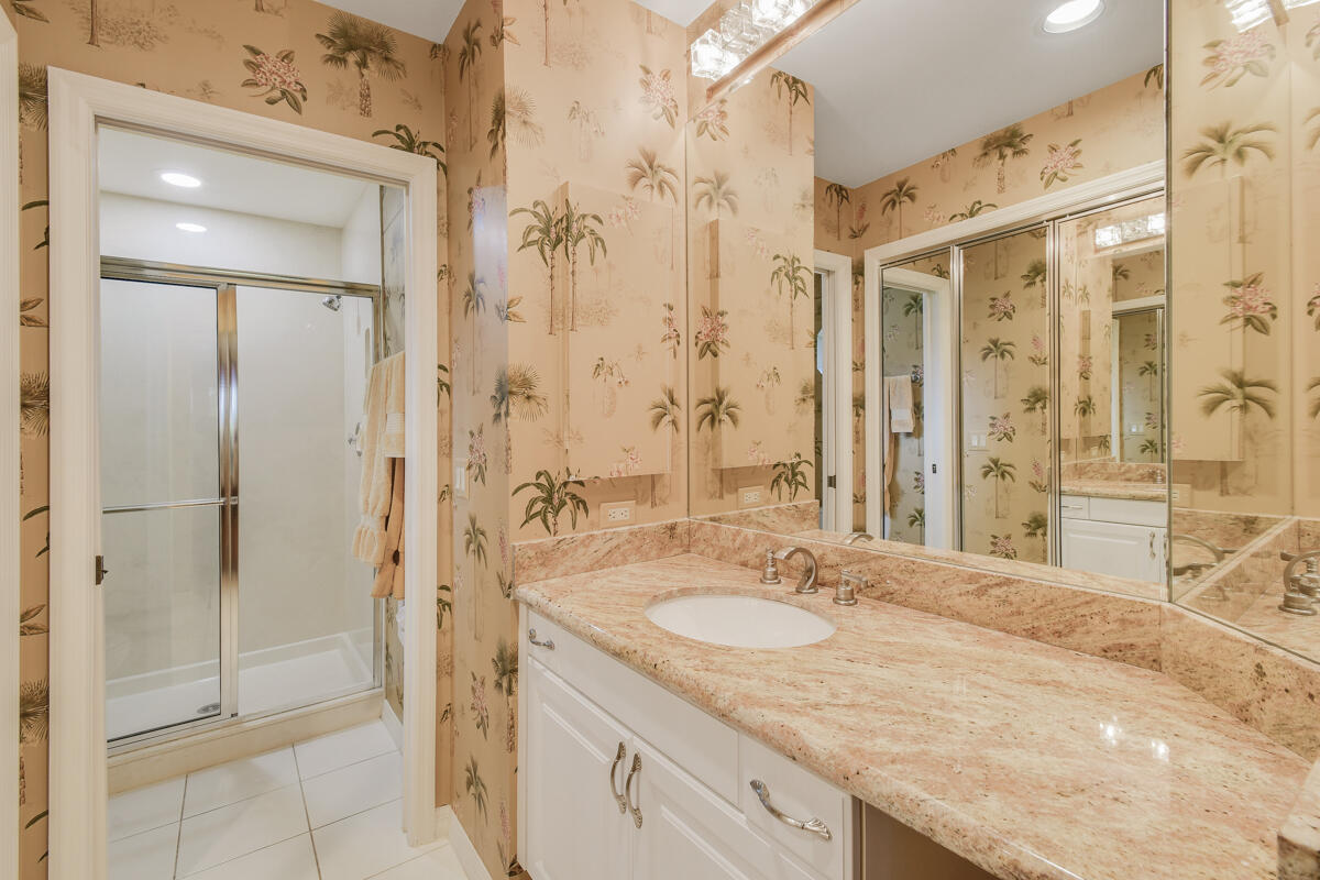 13312 Northwest Maplewood Road Palm City, FL 34990 - Photo 39 of 69 a bathroom with a granite countertop sink a shower and a mirror