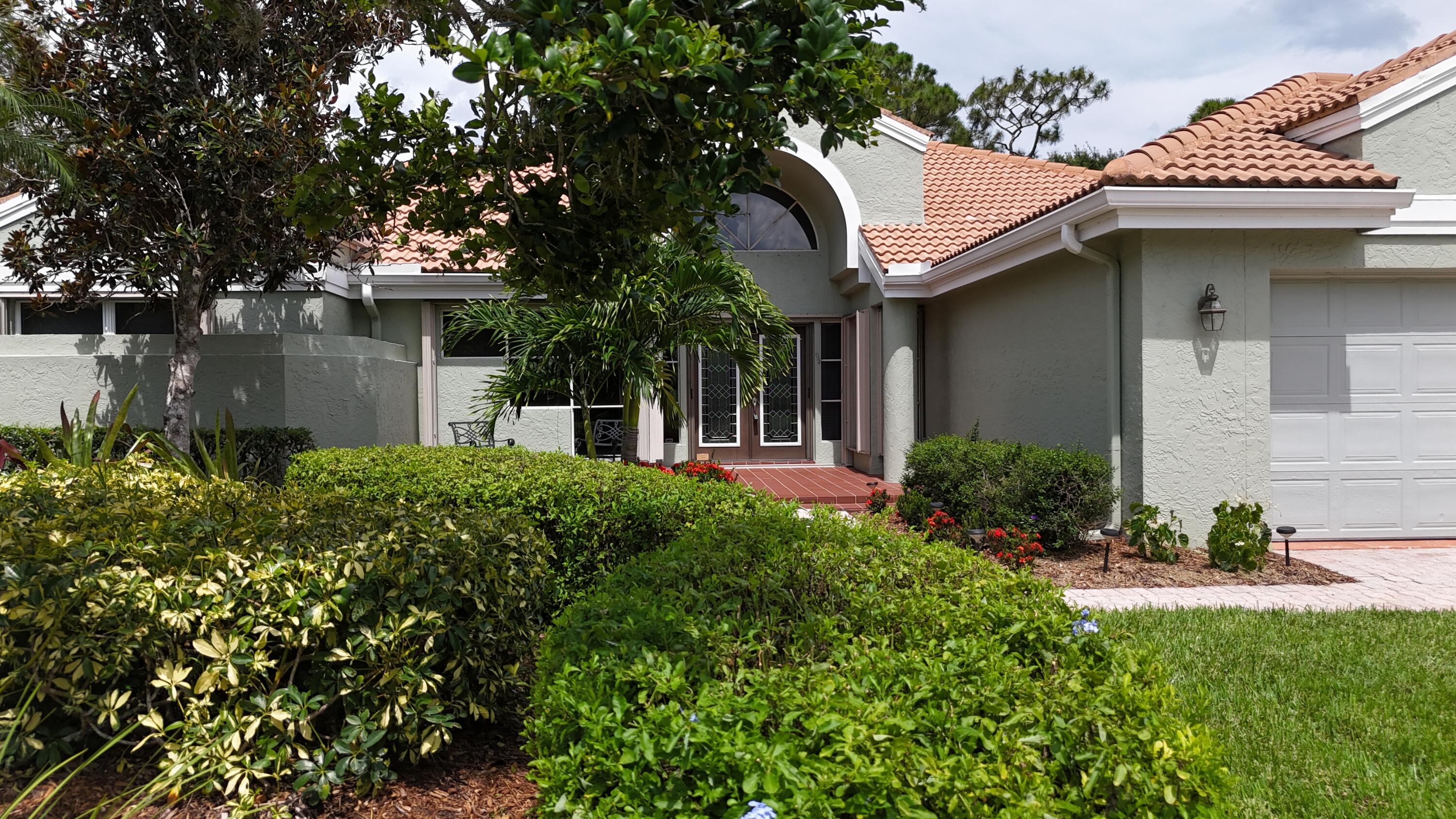 13312 Northwest Maplewood Road Palm City, FL 34990 - Photo 5 of 69 a front view of a house with garden