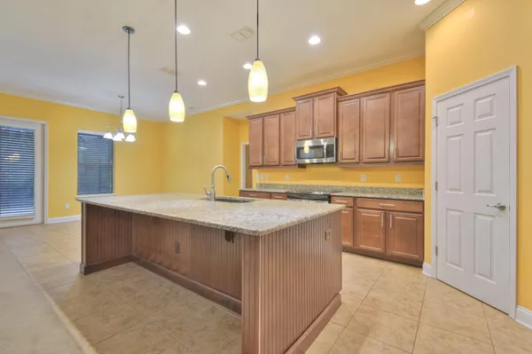 a kitchen with a sink a center island a stove and a wooden cabinets