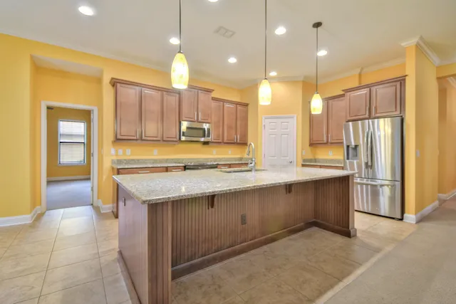 a kitchen with kitchen island granite countertop a sink appliances and cabinets