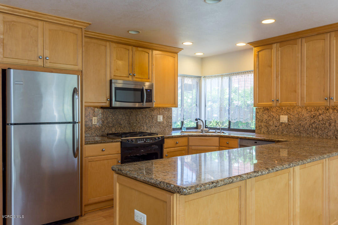 1616 Old Ranch Road Camarillo, CA 93012 - Photo 7 of 9 a kitchen with stainless steel appliances granite countertop a refrigerator a stove and a sink with wooden cabinets