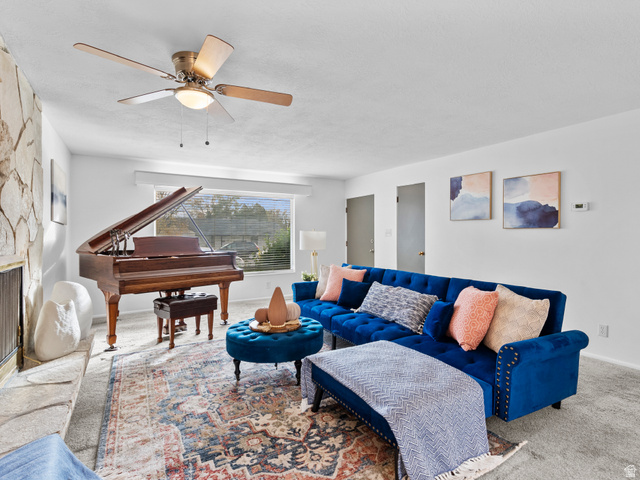 1051 300 North Provo, UT 84606 - Photo 1 of 1 Carpeted living room featuring a stone fireplace and a ceiling fan