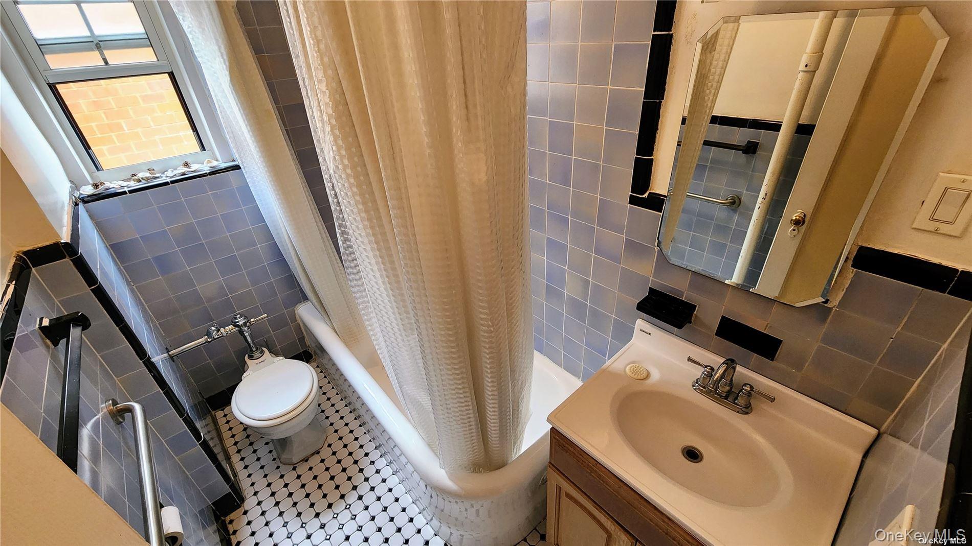 4 Maple Drive, Unit 6H Great Neck, NY 11021 - Photo 14 of 14 a bathroom with a sink and a mirror