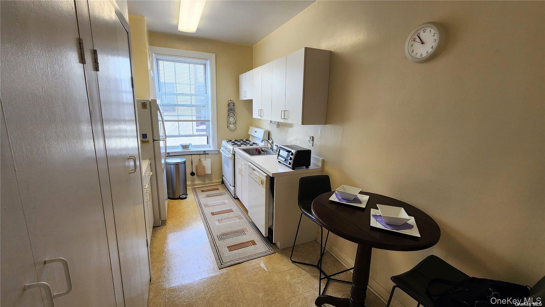 4 Maple Drive, Unit 6H Great Neck, NY 11021 - Photo 6 of 14 a kitchen with stainless steel appliances kitchen island granite countertop a refrigerator a stove and a sink